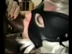 A masked wife engages in an interracial threesome with two large black men.